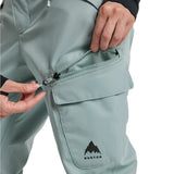 Burton Women's Gloria 2L Stretch Pants 2025 - A pair of light gray snow pants with a zippered pocket on the thigh and a black logo at the bottom.