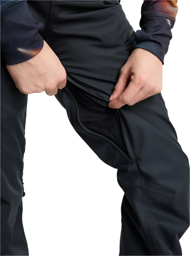 Burton Women's Gloria 2L Stretch Pants (Short) - Black pants with a subtle pattern of thin white lines on the left leg, worn by a model from the waist down against a light gray background.