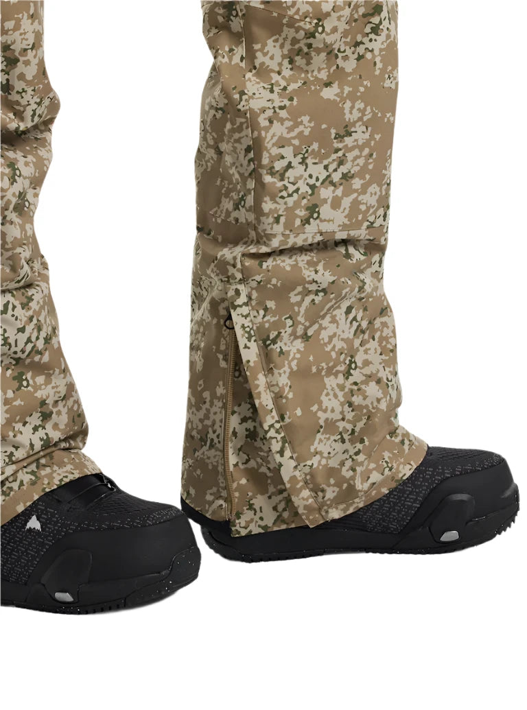 Burton Women's Reserve 2L Stretch Bib Pants 2025 - A pair of tan snow pants with a green and white abstract pattern, featuring a zippered fly and adjustable cuffs.