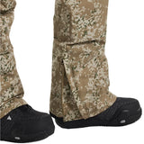 Burton Women's Reserve 2L Stretch Bib Pants 2025 - A pair of tan snow pants with a green and white abstract pattern, featuring a zippered fly and adjustable cuffs.