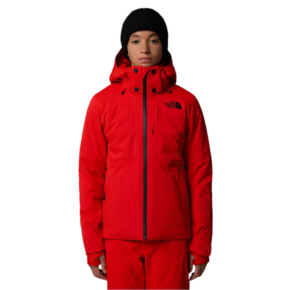North Face Women's Lenado Insulated Jacket - A woman wearing a red jacket with black buttons and a logo on the left chest, standing against a white background.