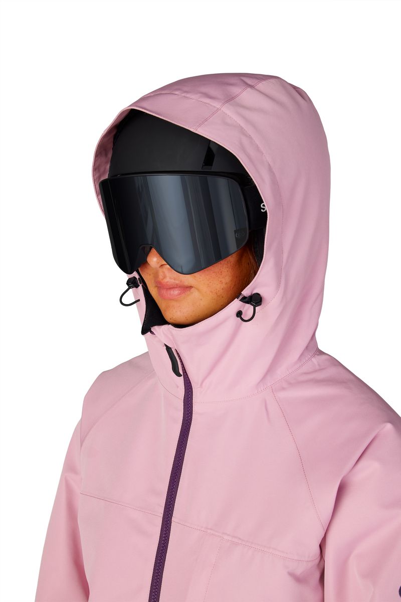 Women's insulated ski jacket, light pink hood up, goggles and face close-up
