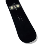 Arbor El Camino - Jared Elston Pro Snowboard 2026 - A black snowboard with a rectangular, rounded rectangle graphic at top center featuring three gauges in a grayish-brown frame.