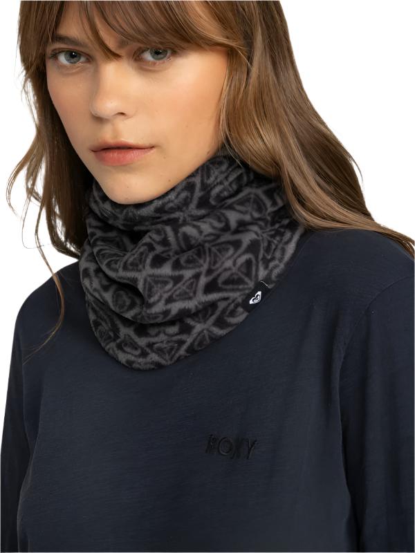 Roxy Women's Sayna Collar - A black fleece neck warmer with a repeating geometric pattern of triangles and lines in white, worn by a model with long brown hair.