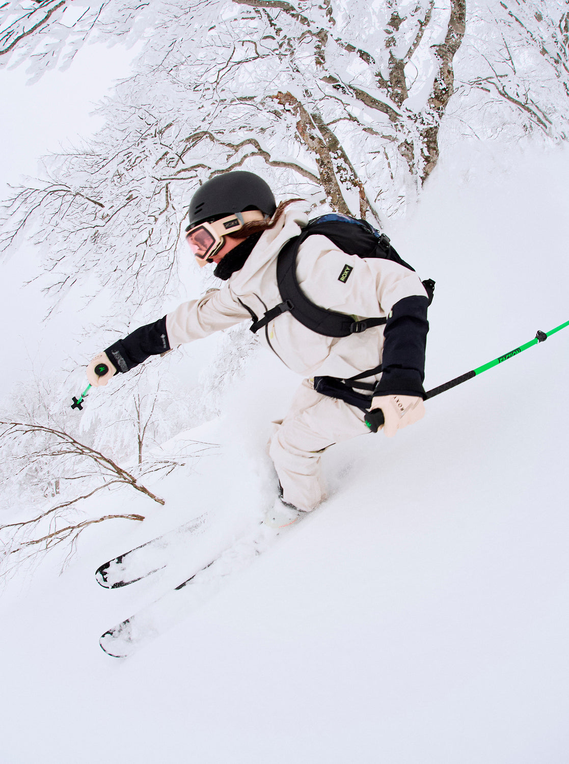 Roxy Women's Lunalite 3L GORE-TEX Jacket 2025 - A white jacket with black accents and a hood, worn by a woman skiing down a snowy slope.