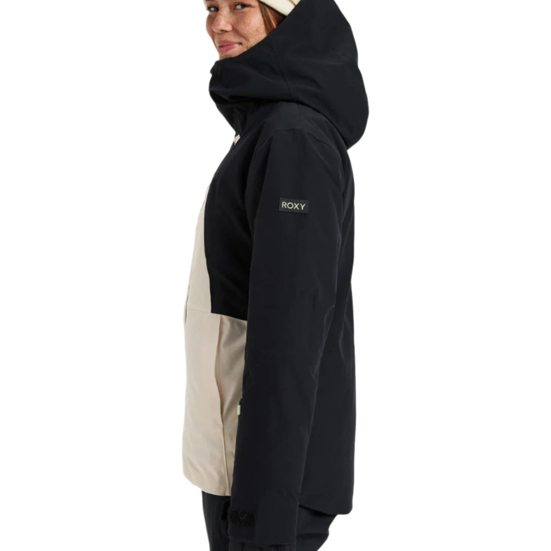 Roxy Women's Wild Twist Jacket 2025 - A black jacket with a tan panel on the side and a hood, featuring a zippered pocket on the left arm.