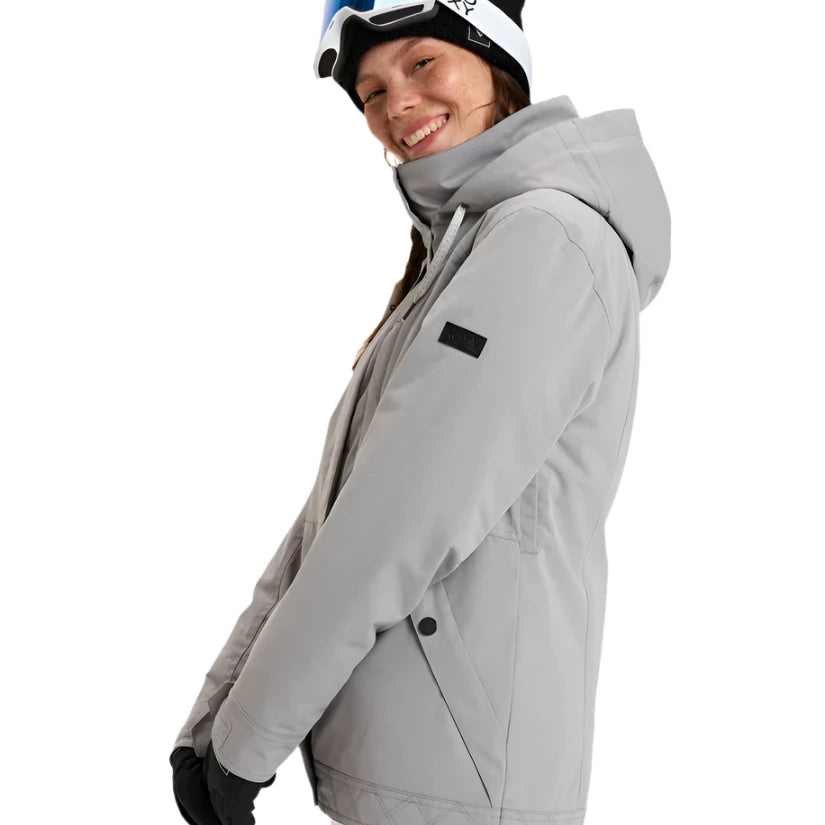Roxy Women's Billie Insulated Jacket 2025 - A light gray jacket with a high collar and zippered pockets, featuring a black patch on the left sleeve.