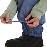 Roxy Women's Chloe Kim Insulated Pant 2025 - A pair of blue snow pants with a white logo on the left leg, featuring a drawstring waistband and elastic cuffs at the ankles.