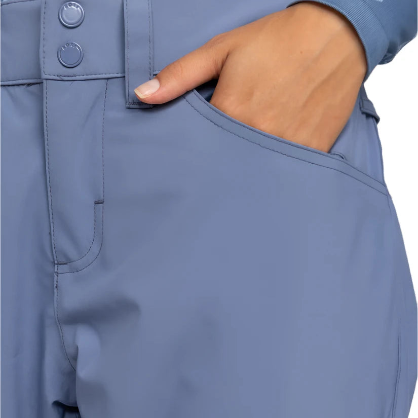 Roxy Women's Backyard Snow Pant 2025 - A pair of light blue snow pants with a geometric pattern on the waistband and two snap buttons.