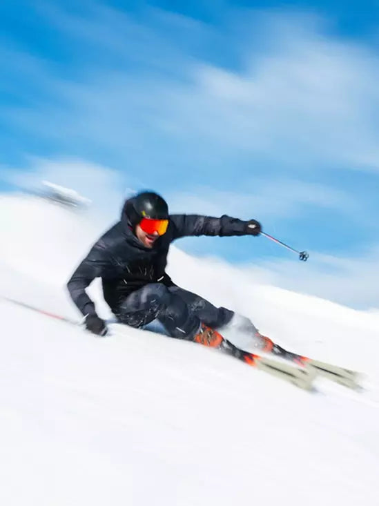 K2 Disruption MTI skis with MXC 12 bindings cut through fresh powder, showcasing a vibrant red and white design.