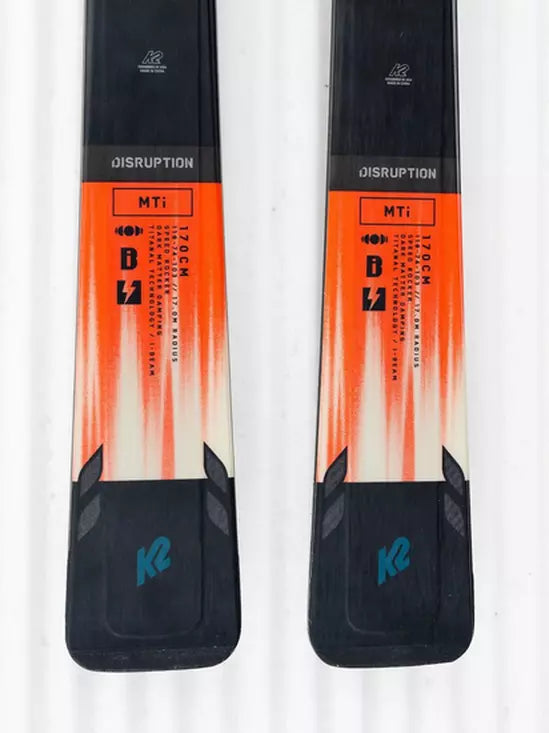 K2 Disruption MTI skis feature a red and black graphic design with MXC 12 bindings.