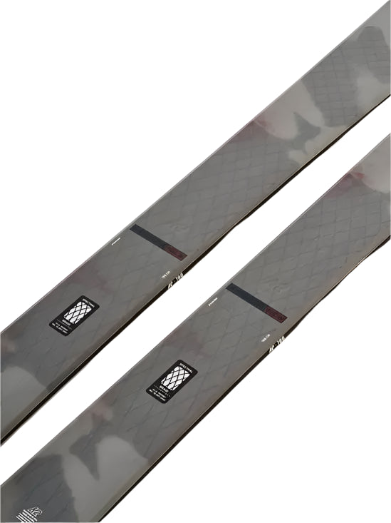 K2 Women's Mindbender 96C skis 2025 feature a black and red design with distinctive graphic patterns.