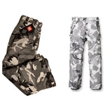 The 686 Defender Cargo Pants 2023 are shown in an olive green and black camouflage pattern.