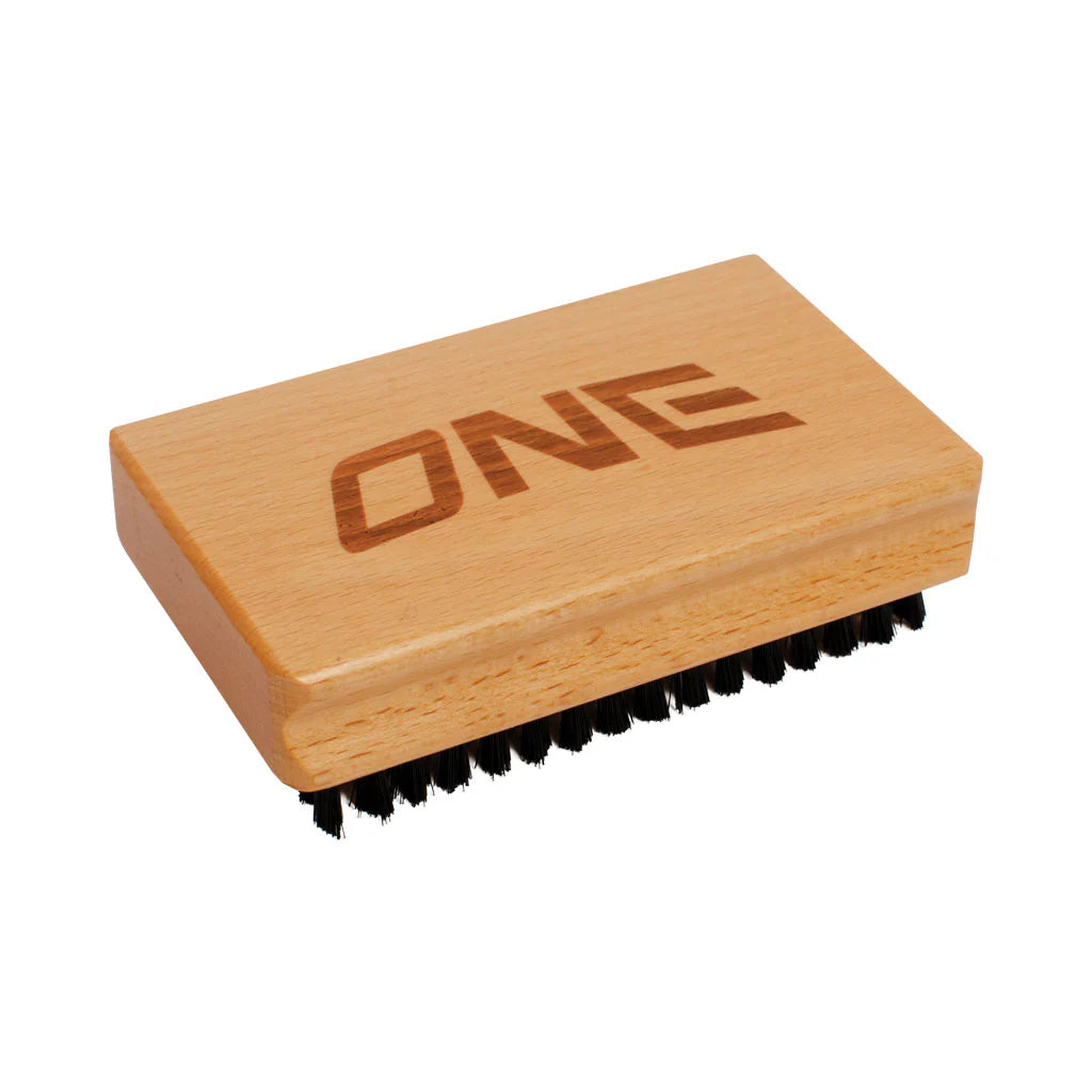 Oneball Brass Nylon Brush Combo 2025 - A small, rectangular brush with a light-colored wooden handle and black nylon bristles.