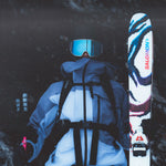 A person wearing a white jacket and blue pants, holding a pair of Salomon S/Lab QST Blank Skis 2026.