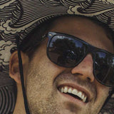 Radar Paddlers Sun Hat - A black sun hat with a white wave pattern on the brim and a black strap at the back.