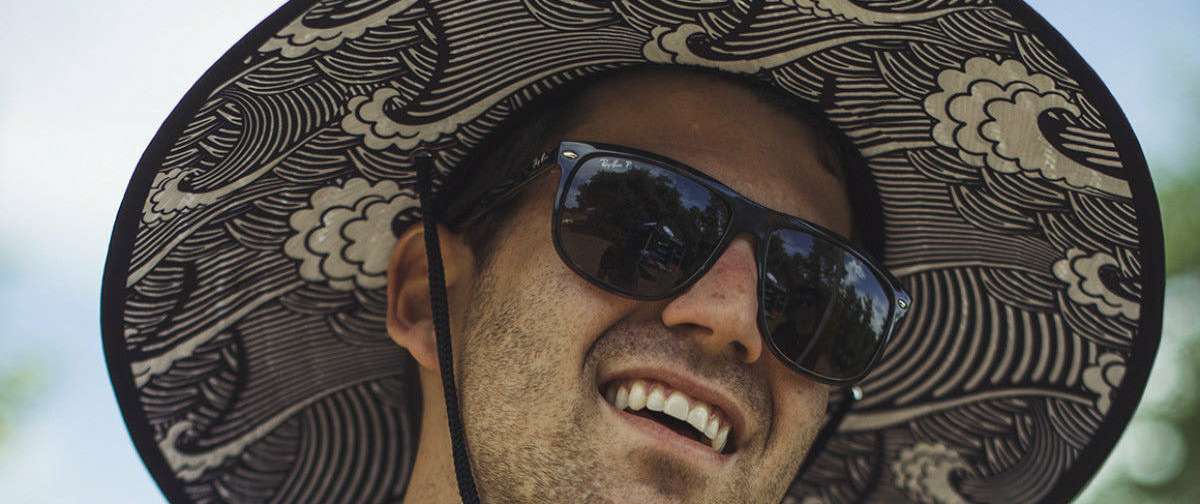 Radar Paddlers Sun Hat - A black sun hat with a white wave pattern on the brim and a black strap at the back.