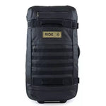 Ride Luggage Roller Snowboard Bag 2025 - A black roller bag with a handle on top and wheels at the bottom, featuring a zippered pocket on the front.