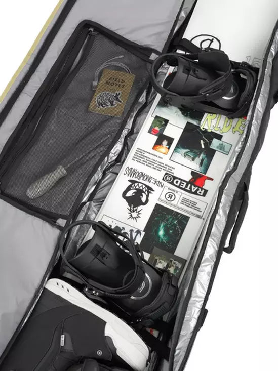 Ride The Perfect Snowboard Bag 2025 - A large, gray snowboard bag with a zippered top and two black wheels on one end.
