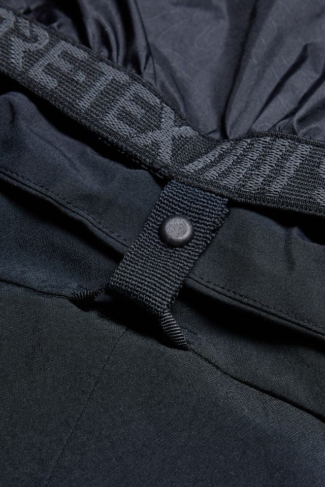 Women’s black cargo pants close-up: snap strap and reinforced fabric