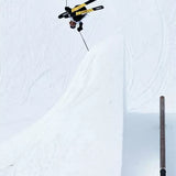 Volkl Revolt 96 Ski 2024 - A skier in a black and yellow jacket is seen from above, mid-air, with their skis parallel to the ground.