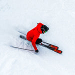 Völkl Mantra 102 Flat Skis 2025 - A pair of black skis with red and yellow markings on the tips, lying flat in snow.