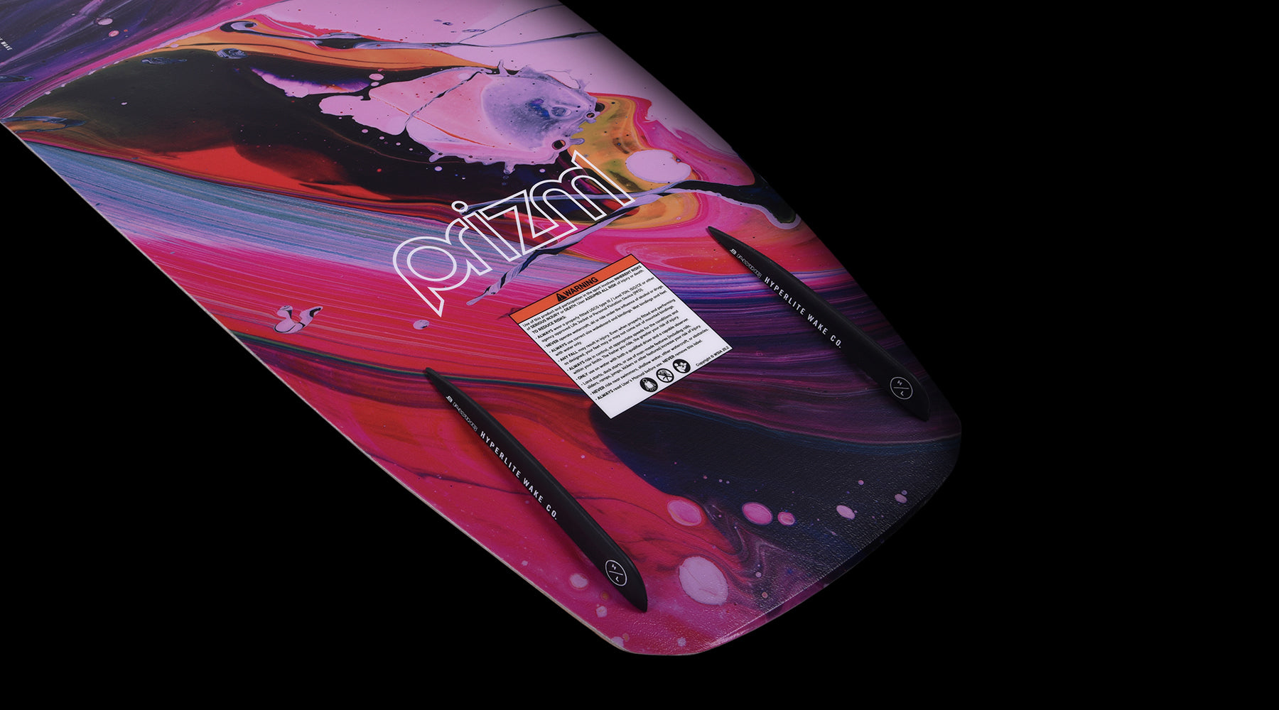 Hyperlite Women's Prizm Wakeboard 2024 - A pink and black wakeboard with a colorful abstract design on its top side.