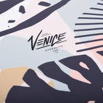 Hyperlite Venice - A white wakeboard with a light blue graphic of a palm tree and abstract shapes, featuring dark gray accents.