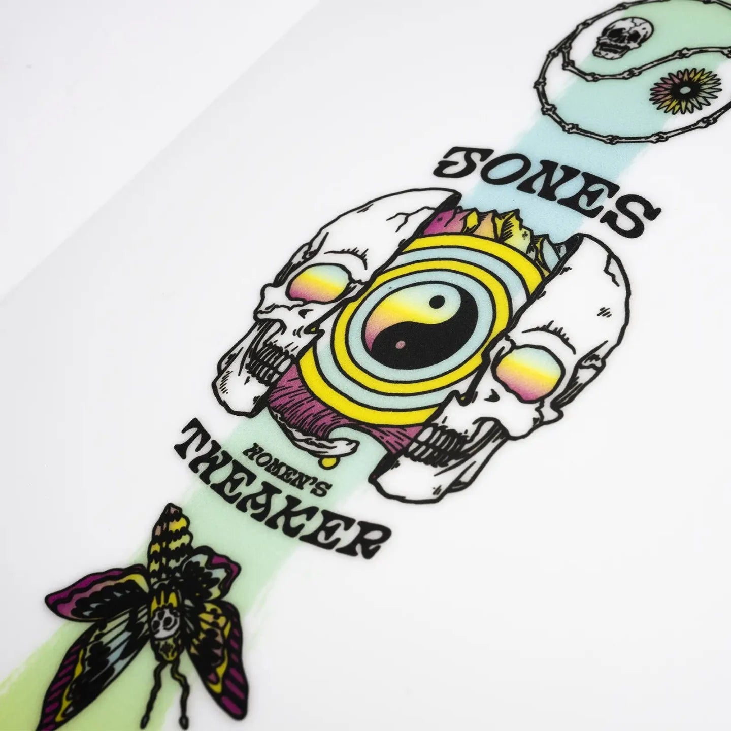 Jones Women's Tweaker Snowboard - A white snowboard with a pink and yellow graphic of a woman in a bikini riding a wave on its top side.
