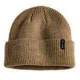 Autumn Select Beanie 2025 - A tan beanie with a small black tag on the front.