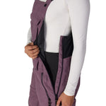 Women’s insulated mauve purple bib overalls with zip front panels and contrast side panels.