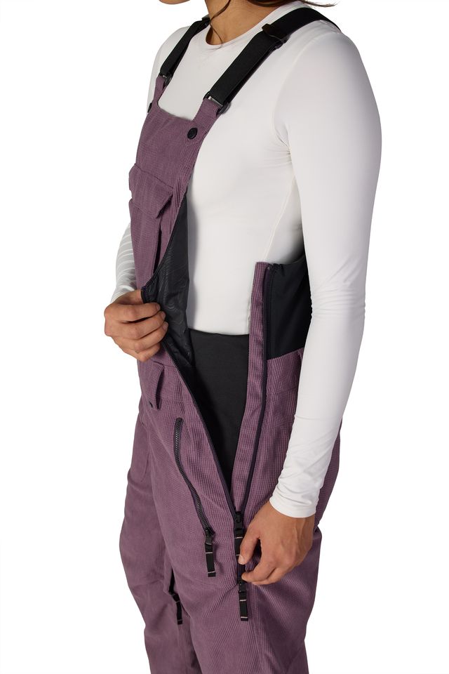 Women’s insulated mauve purple bib overalls with zip front panels and contrast side panels.