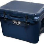 Yeti Tundra 35 Hard Cooler - A navy blue cooler with a white logo on the front and two black latches on top.