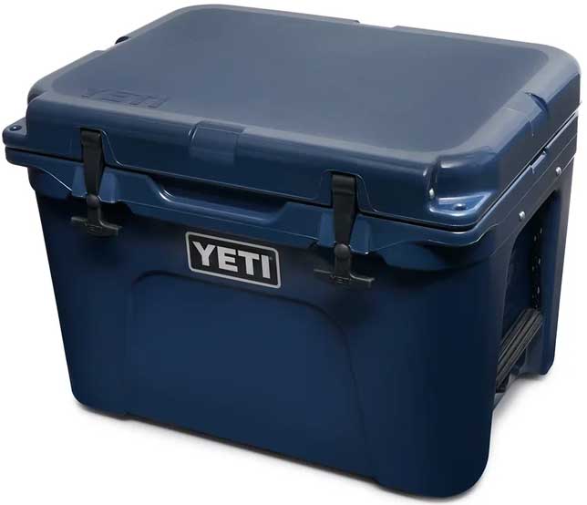 Yeti Tundra 35 Hard Cooler - A navy blue cooler with a white logo on the front and two black latches on top.