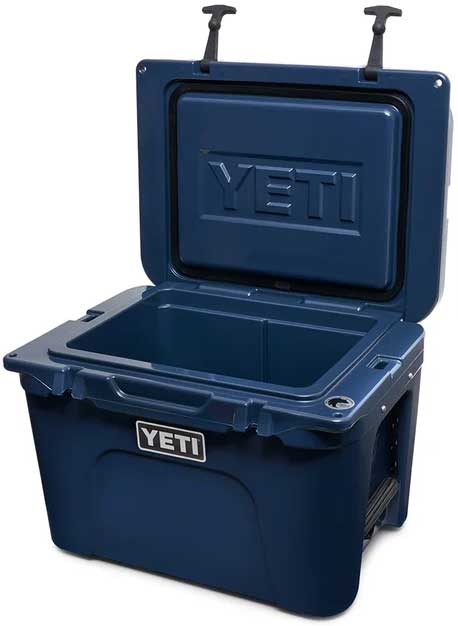 Yeti Tundra 35 Hard Cooler - A navy blue cooler with a raised "YETI" logo on its lid.