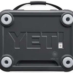 Yeti Roadie 24 Hard Cooler - A dark gray cooler with a handle on top and four round feet, featuring the word "YETI" embossed in large letters across its front.