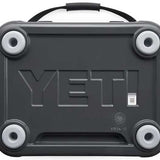 Yeti Roadie 24 Hard Cooler - A dark gray cooler with a handle on top and four round feet, featuring the word "YETI" embossed in large letters across its front.