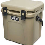 Yeti Roadie 24 Hard Cooler - A tan-colored cooler with a handle on one side and a latch on top.