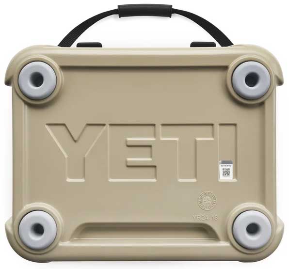 Yeti Roadie 24 Hard Cooler - A tan-colored cooler with a handle on top and four circular feet, featuring embossed lettering that reads "YETI" in large letters across its front.