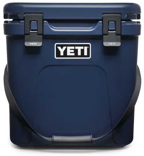 Yeti Roadie 24 Hard Cooler - A navy blue cooler with a handle on top and two latches, one on each side.