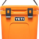 Yeti Roadie 24 Hard Cooler - A compact, portable cooler with a sleek design and a silver handle on top.