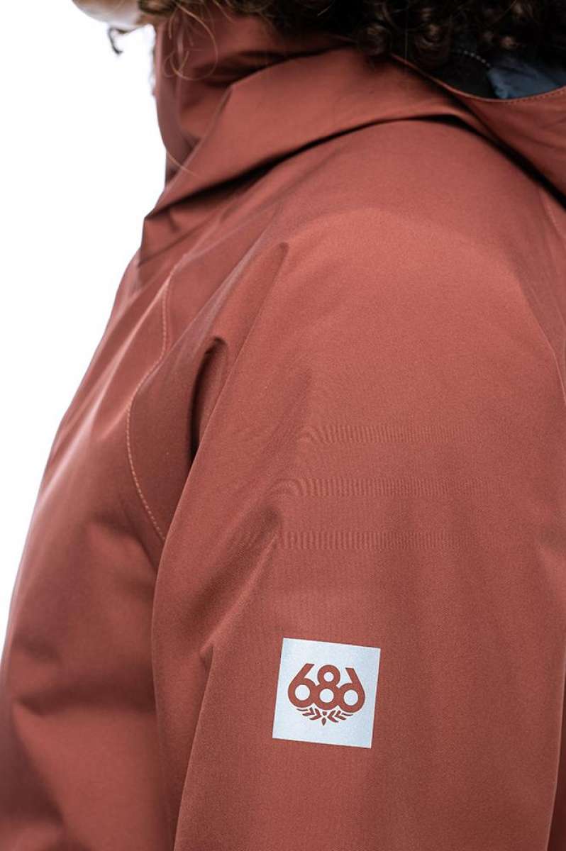 The 686 Lady's GLCR Gore-Tex Willow Insulated Jacket 2022 is primarily red with a black faux fur-lined hood.