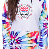The 686 Women's Bonded Fleece Pull-Over Hoodie in white has a bold multicolored tie-dye pattern with splashes of purple, blue, pink, orange and yellow on the sleeves, hood and body.