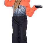 The 686 Girls Shine Insulated One-Piece Snowsuit is black with an abstract white and grey pattern on top, accented by bright orange cuffs, collar, and zipper.