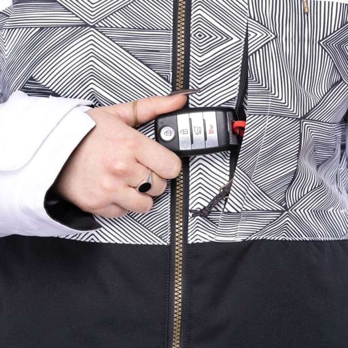 The 686 Women's Athena Insulated Jacket 2022 features a black and white geometric pattern on the chest area with an insulated hood.