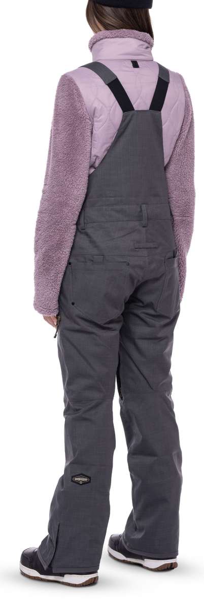 The 686 Ladies Black Magic Insulated Bib features a black bib with a quilted pattern and elastic suspenders.