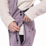 The 686 Ladies Black Magic Insulated Bib 2023 appears in an off-white color with black accents and a quilted pattern on the front.