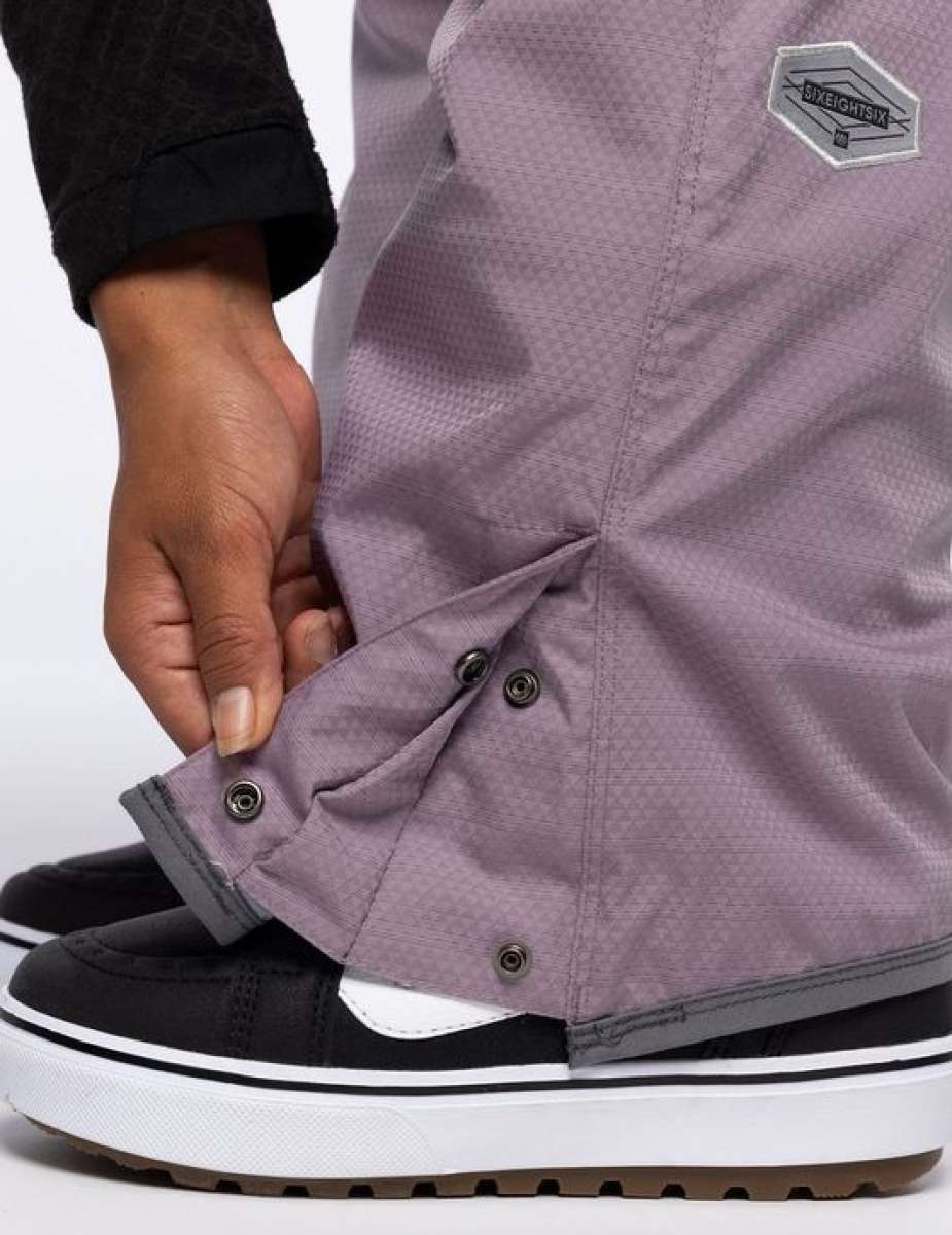 The 686 Ladies Black Magic Insulated Bib 2023 is primarily black with grey accents and has an adjustable waistband.