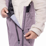 The 686 Ladies Black Magic Insulated Bib appears in a side view, showcasing a black color with a quilted pattern and a zippered fly.