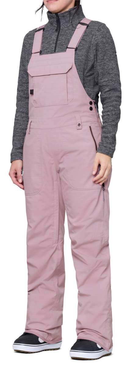 The 686 Black Magic Insulated Bib Pants are showcased in black with distinctive diagonal stripes on the front and back.